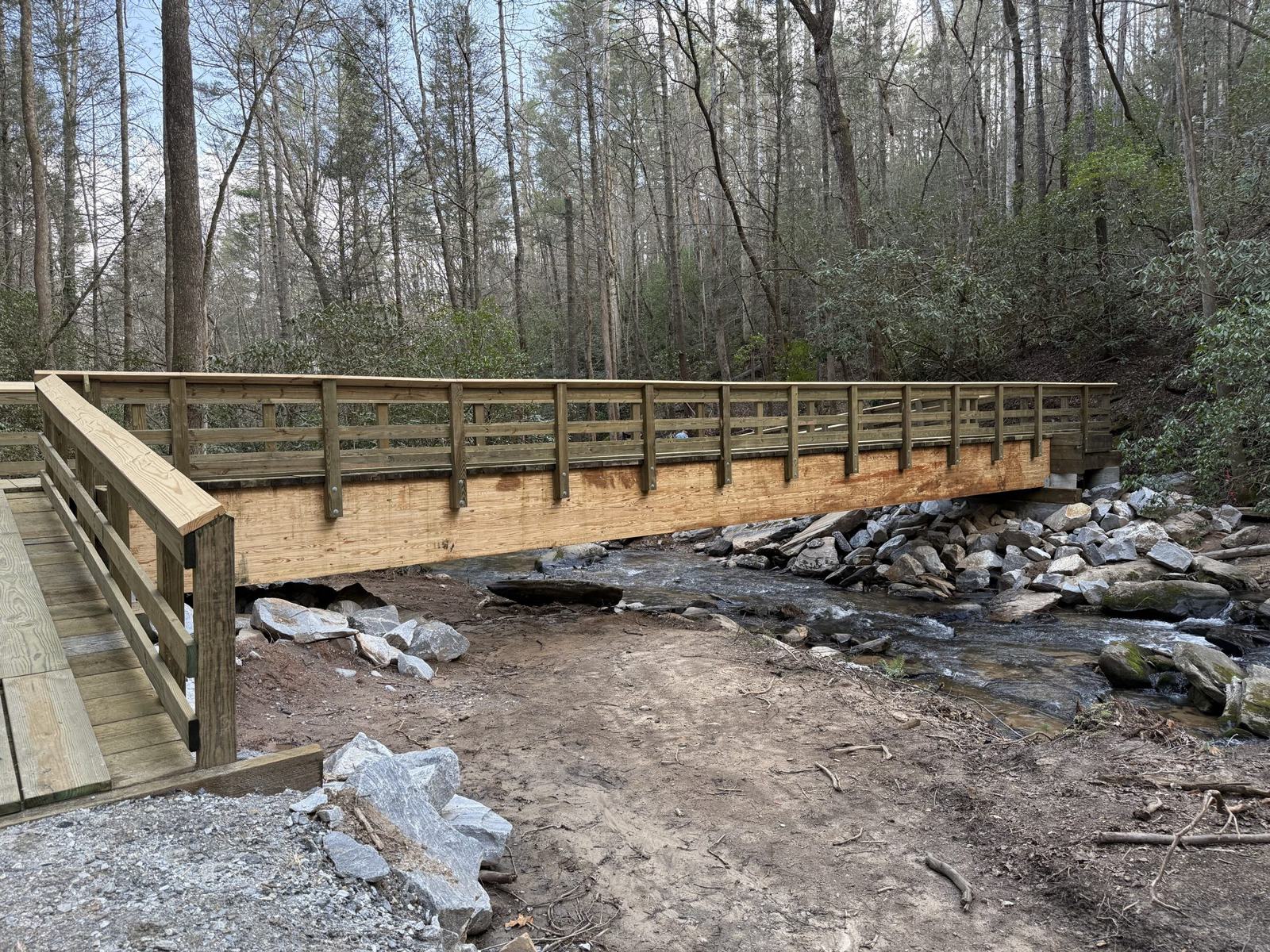 Timber trail bridge spanning a rocky mountain creek